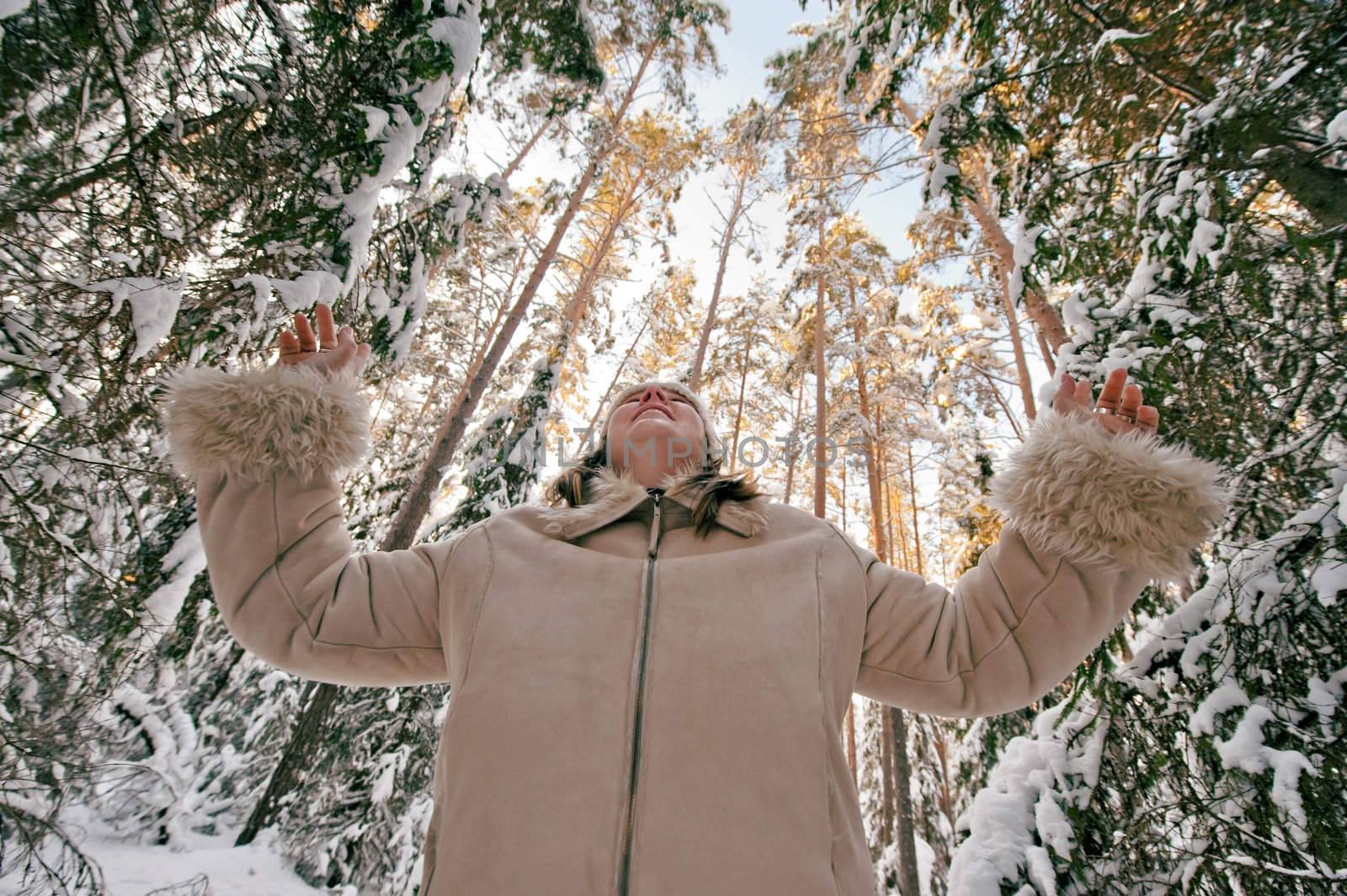 Happy middle-aged women having fun on winters day in forest.