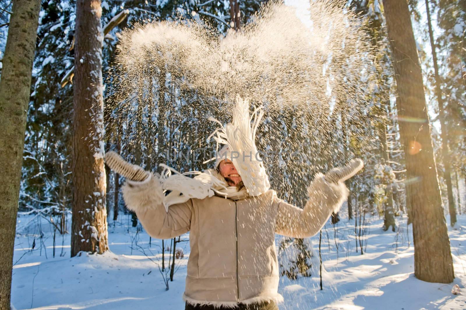 Happy middle-aged women having fun on winters day in forest.