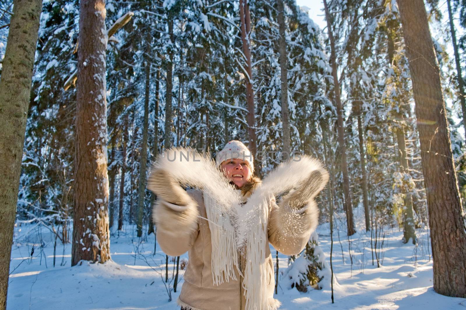 Happy middle-aged women having fun on winters day in forest.