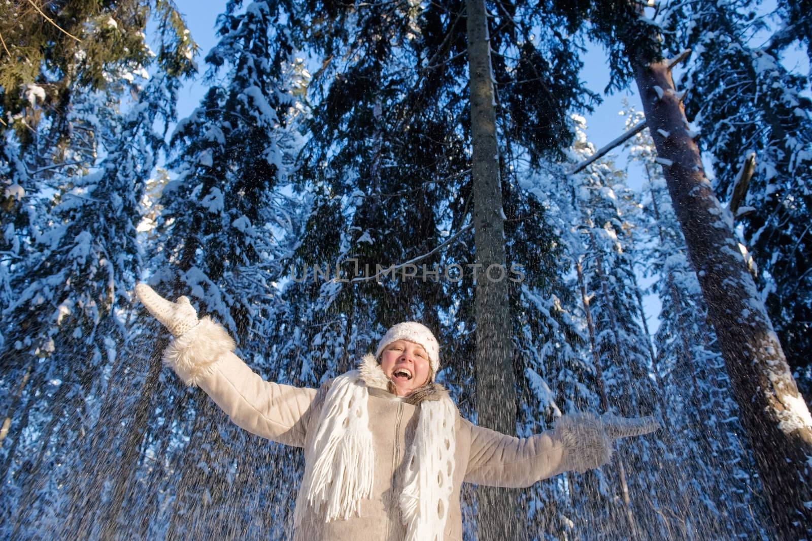 Happy middle-aged women having fun on winters day in forest.