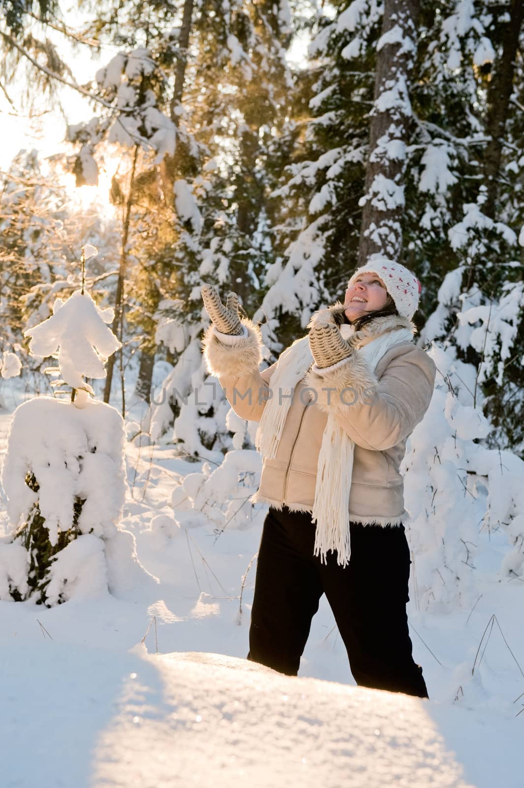 Happy middle-aged women having fun on winters day in forest.