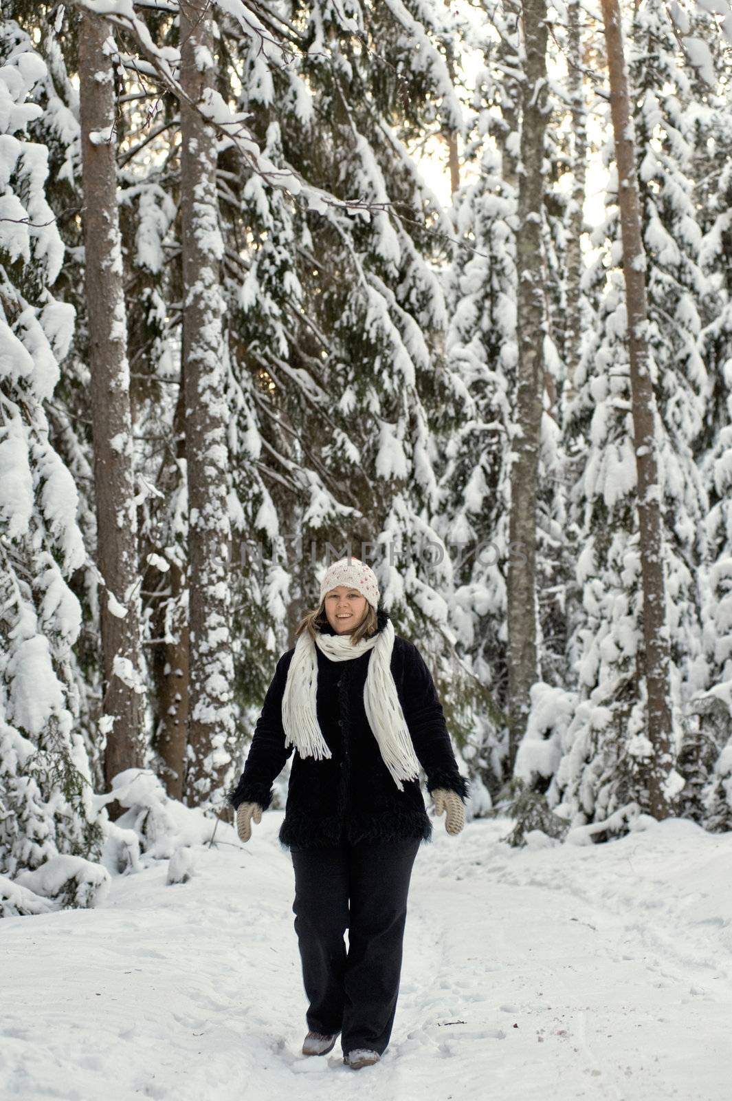 Happy middle-aged women having fun on winters day in forest.