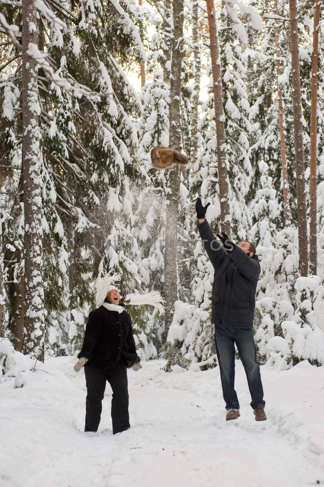 Happy middle-aged couple jumping on a winter day 
