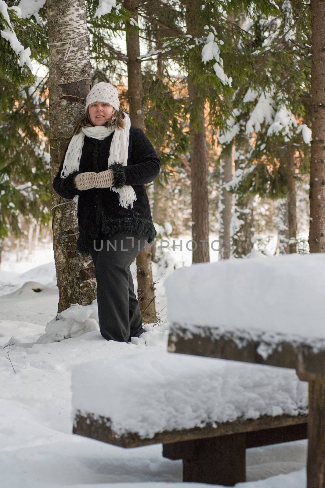 Happy middle-aged women having fun on winters day in forest.