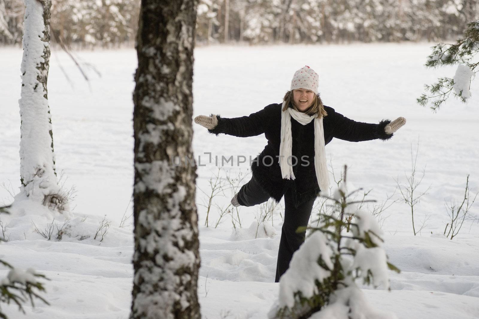 Happy middle-aged women having fun on winters day in forest.