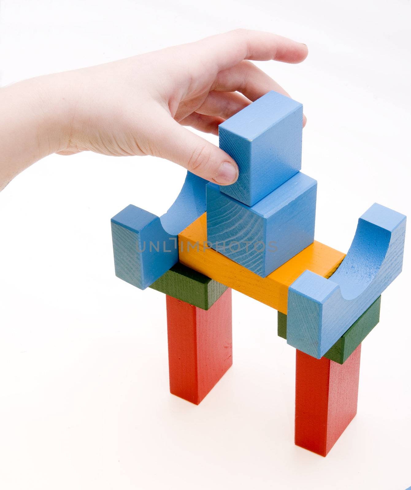child is playing with wooden blocks - making a building