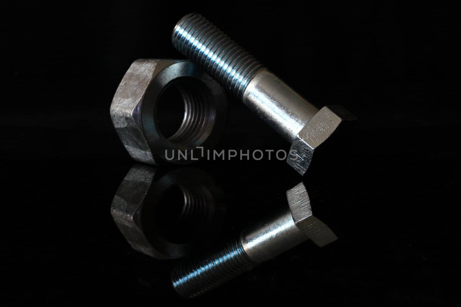 Female screw and screw-bolt on black background                            