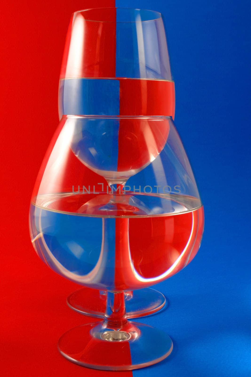 Two glasses on a blue-red background.                               