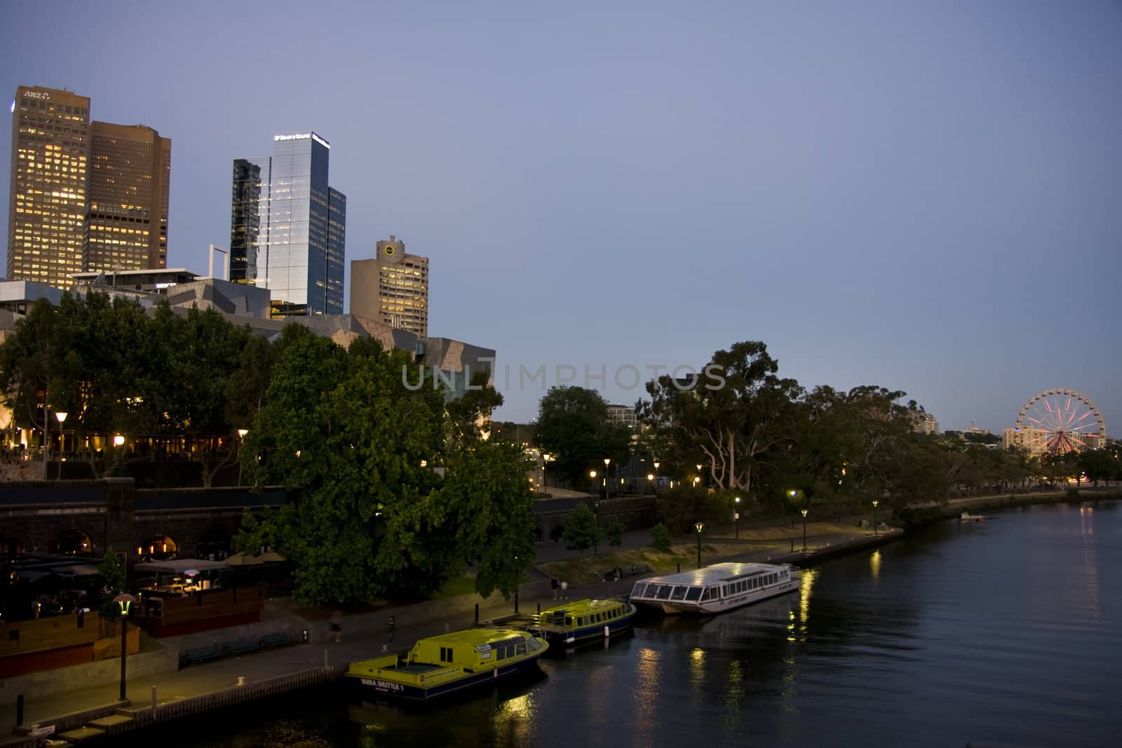 Melbourne skyline on yarra river at twilight with reflection in the water and the colorful ferris wheel. 