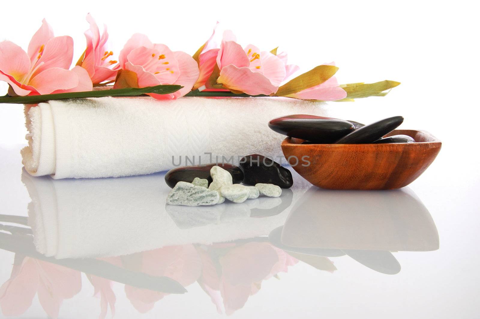 wellness zen and spa still life with flower towel and pebbles isolated on white