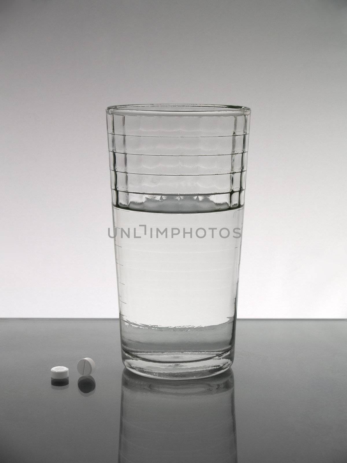 A glass of water with two pills