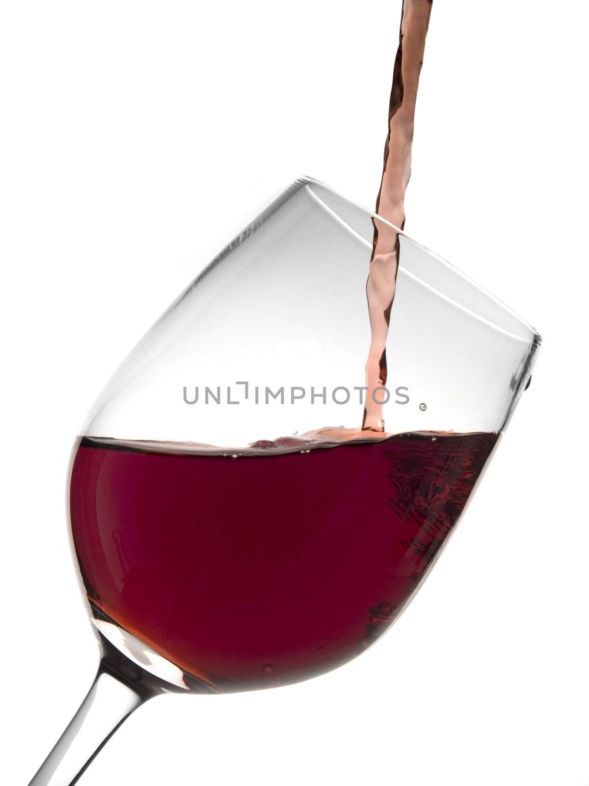 A malbec glass being poured with red wine.