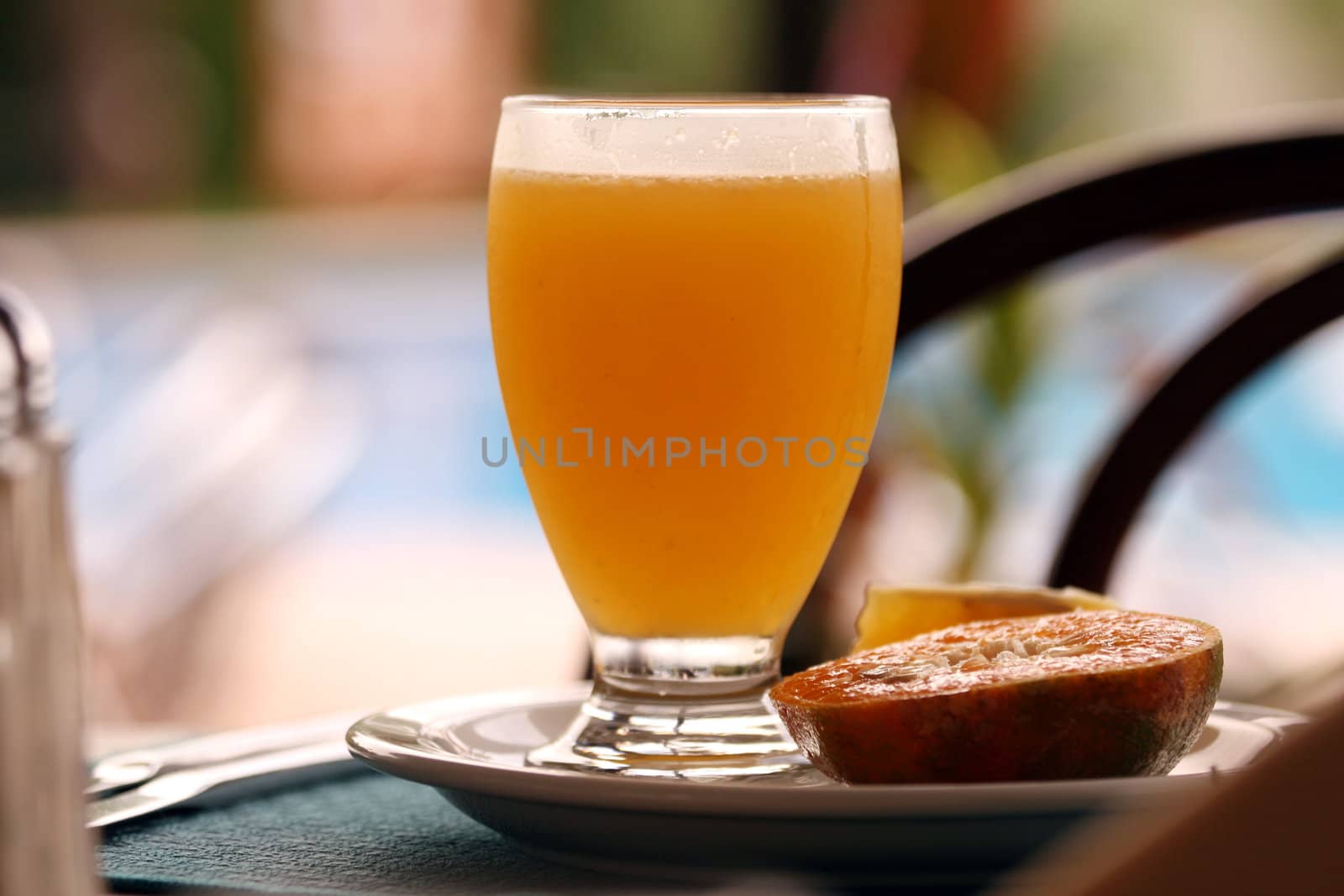 fresh glass juice with orange on the dinner plate