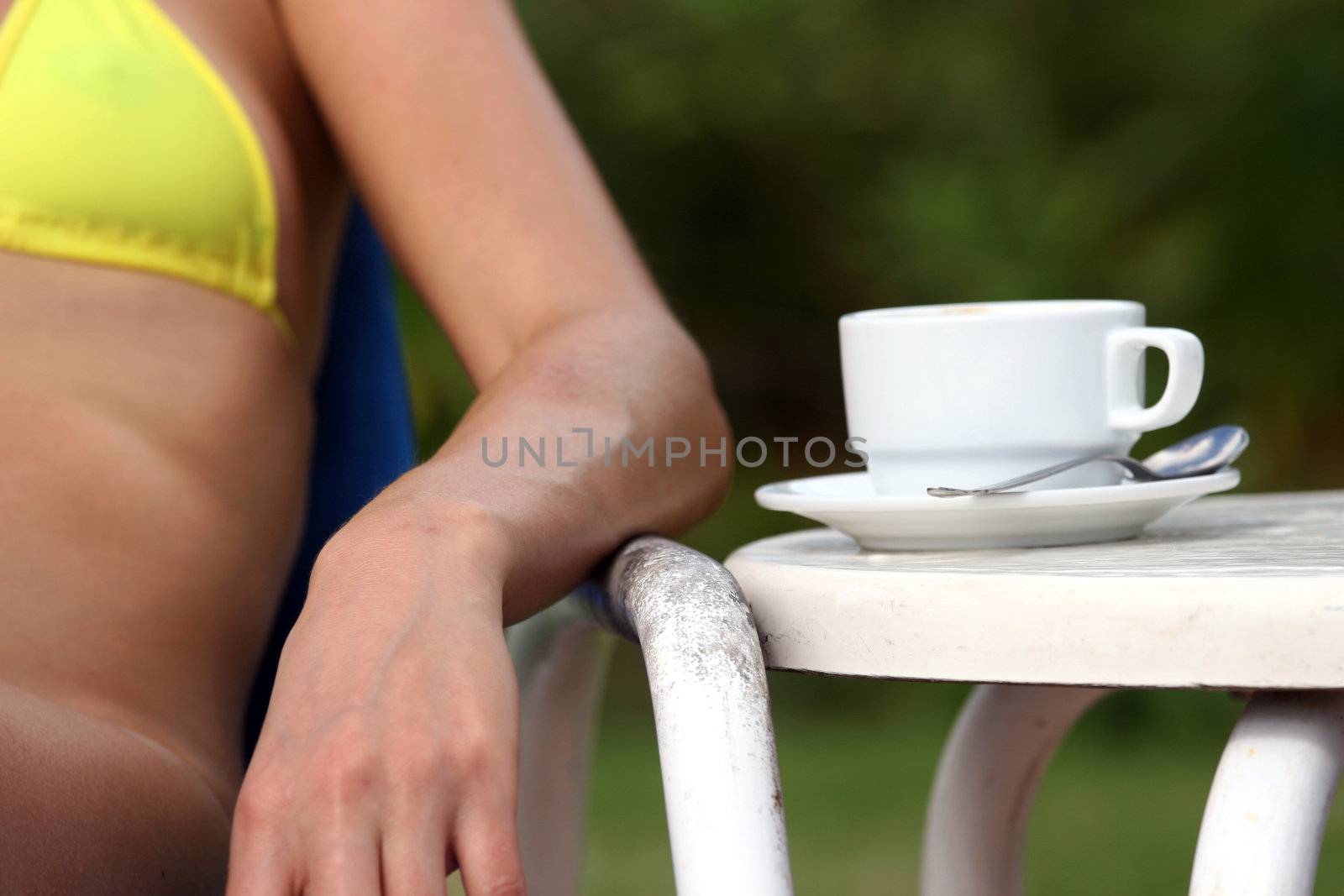 coffee cup on the table and a woman on the left side.