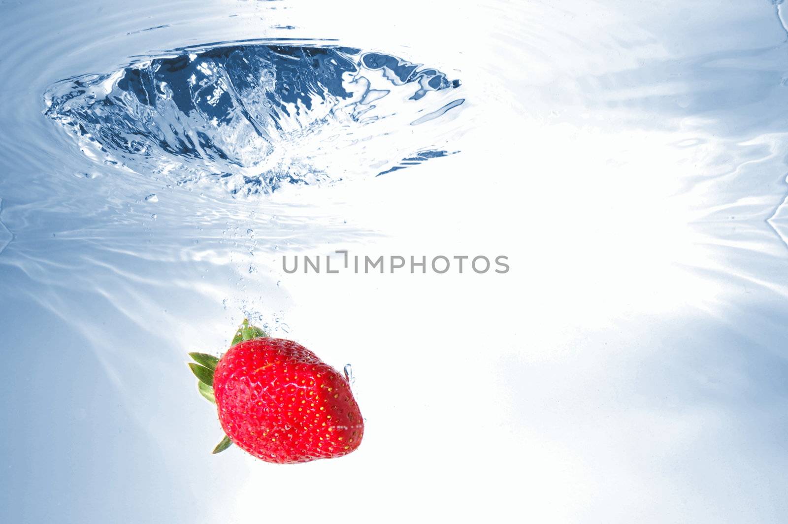 strawberry splash in warter showing healthy lifestyle