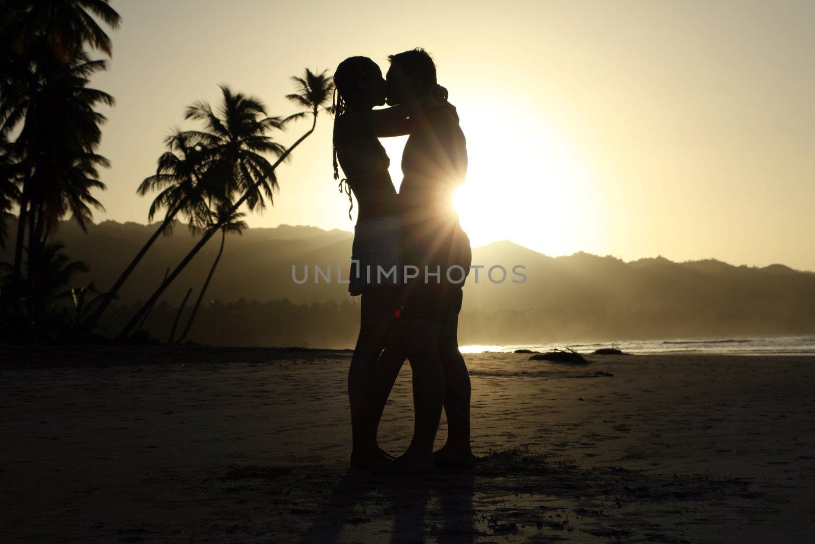 silhouette couple at the beach by sunset