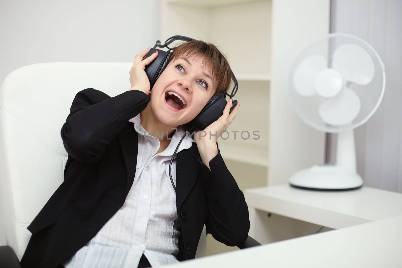 Emotional woman listening to loud music with big headphones