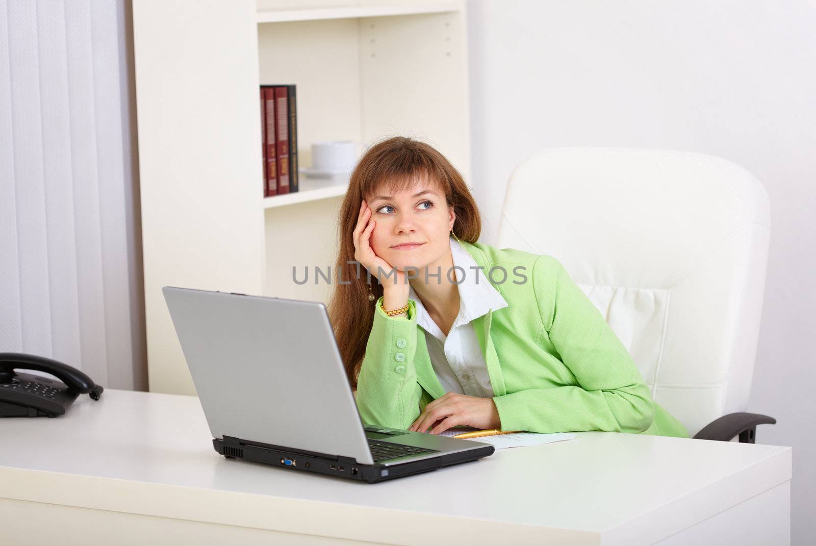 Dreamy woman at the workplace in the office