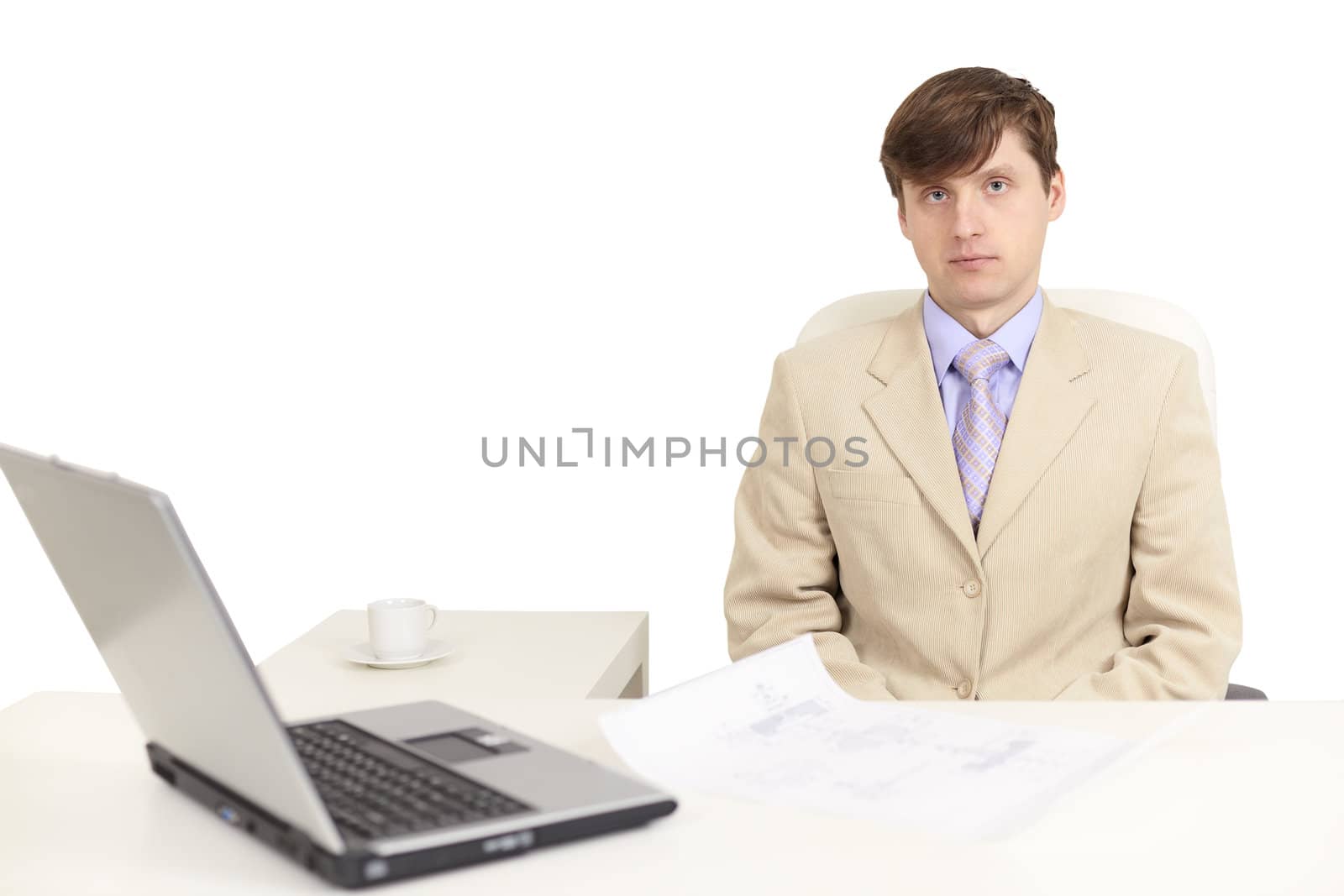 The young serious person on a workplace with the laptop