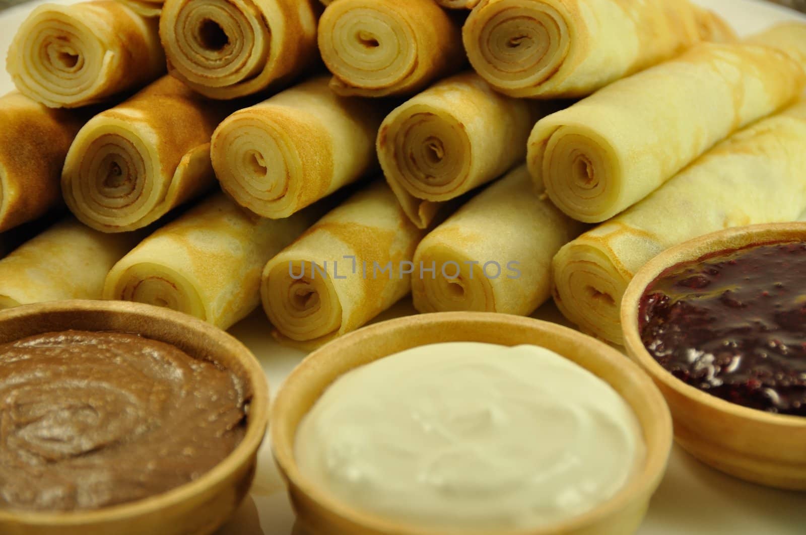 Rolled Pancakes with Cranberry Jam, Chocolate and Sour Cream, close-up