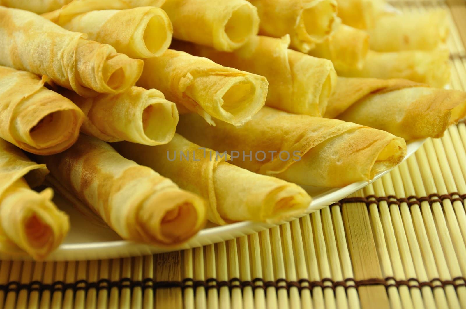 Rolled Pancakes Pile on Bamboo Placemat, close-up