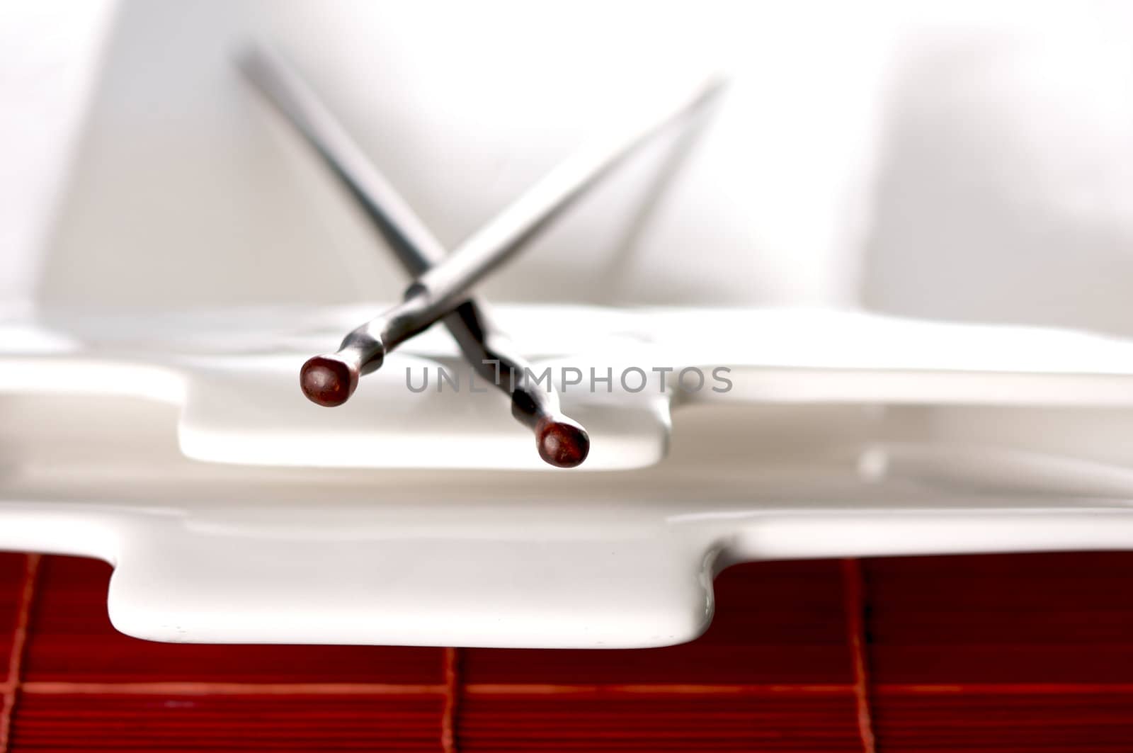 Wooden Chopsticks & White Plate on Bamboo Placemat