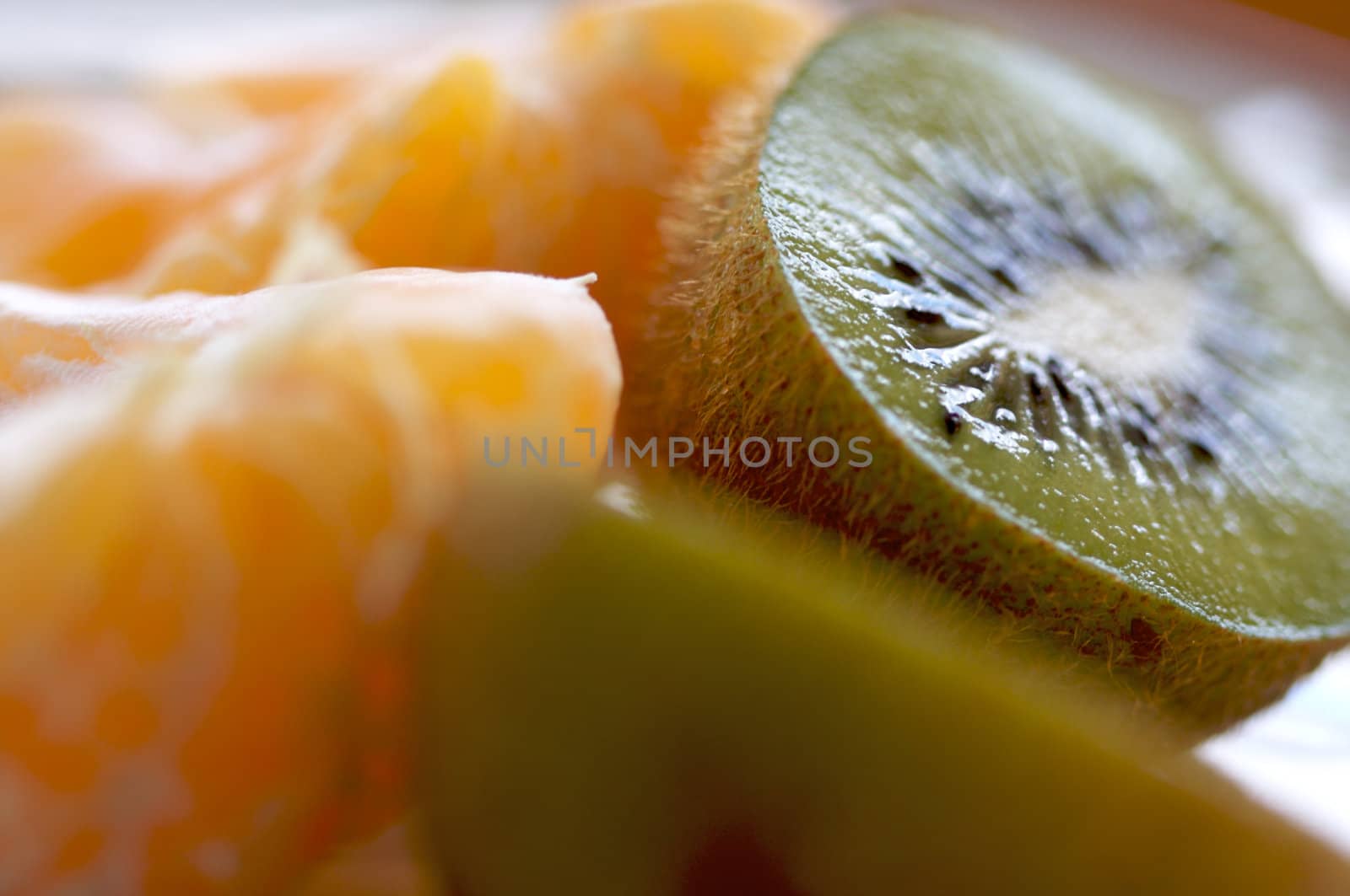 Kiwi and Clementine Tangerines on a plate in early morning light.