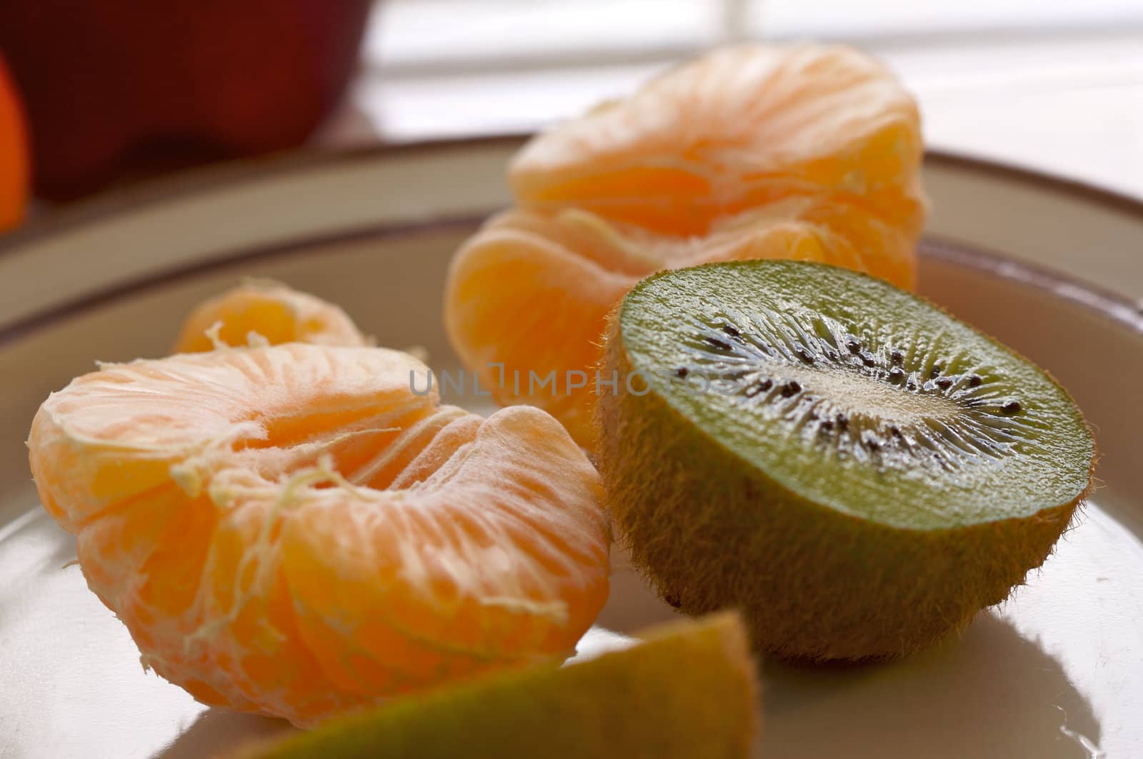 Kiwi and Clementine Tangerines on a plate in early morning light.