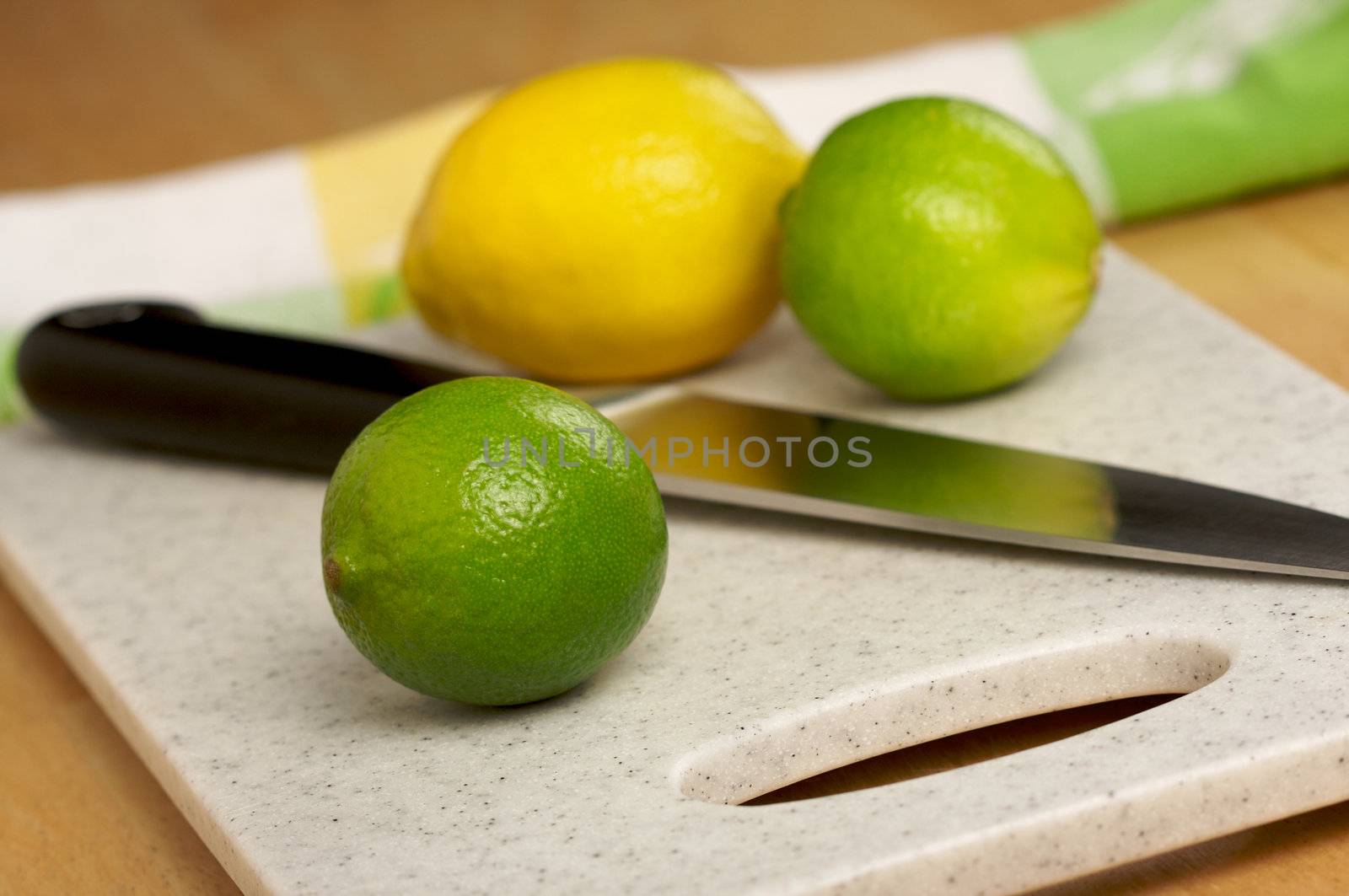 Limes, Lemons and Knife on Cutting Board