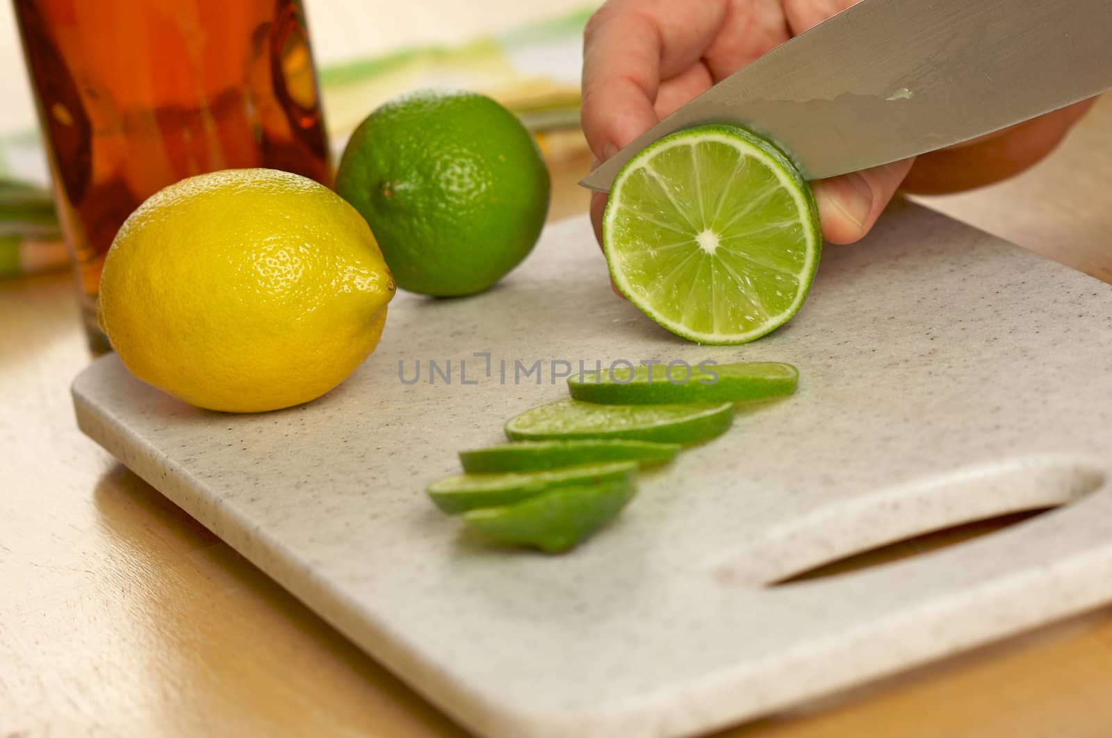 Slicing a lime on a cutting board.