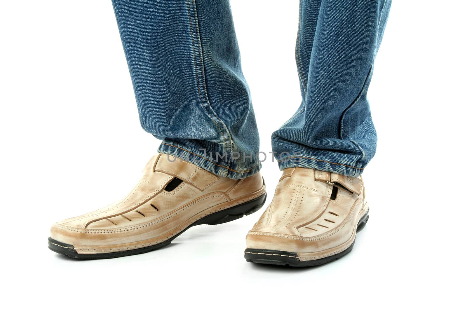 Human foots with brown leather shoes and jeans, isolated on white