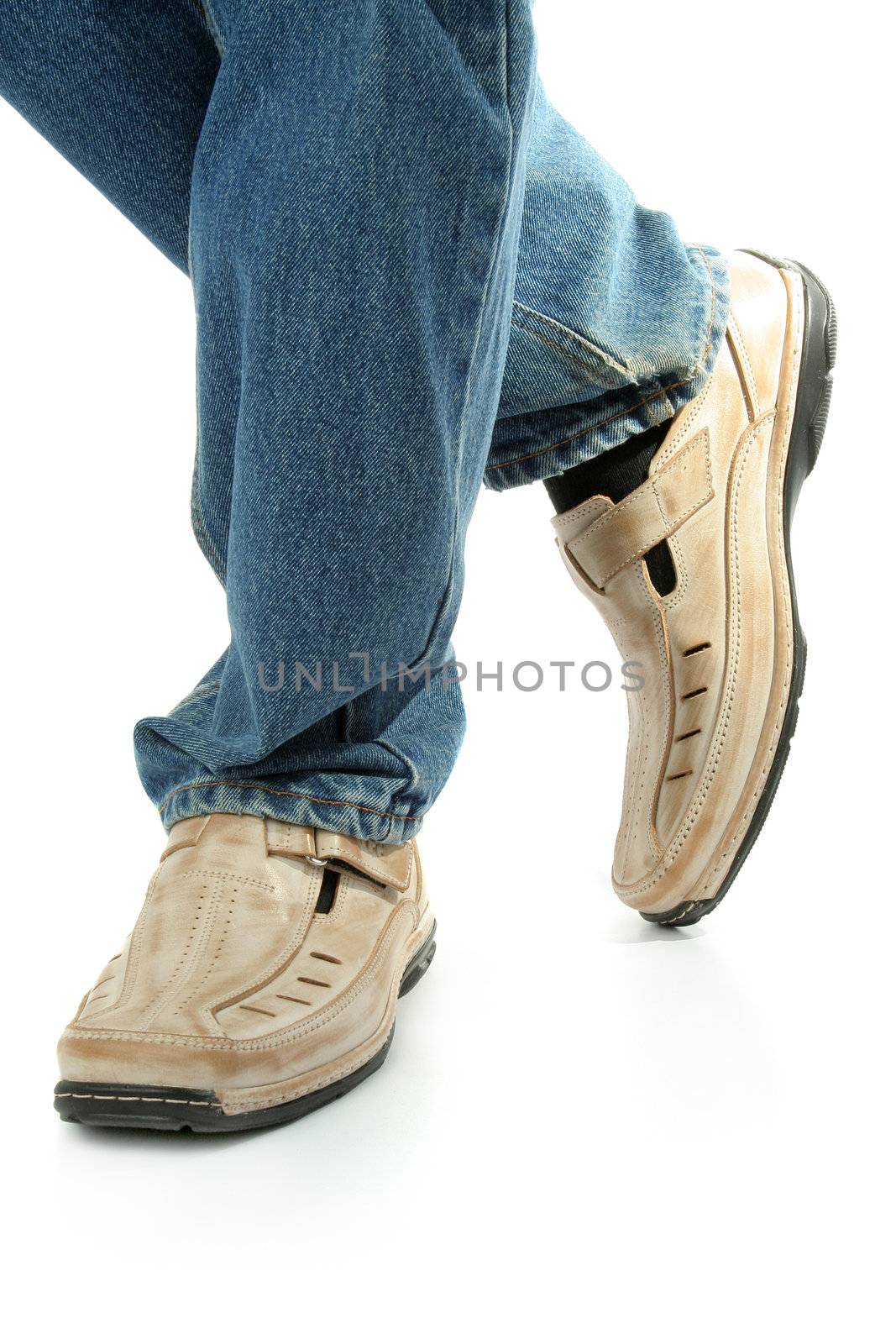 Human foot with brown leather shoes and jeans, isolated on white