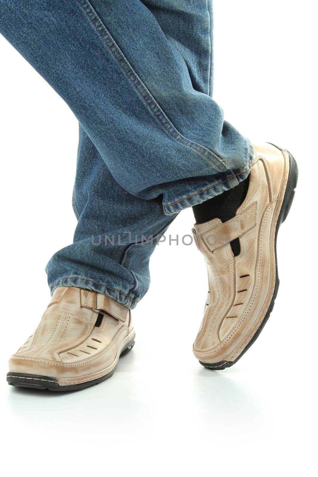 Human foot with brown leather shoes and jeans, isolated on white