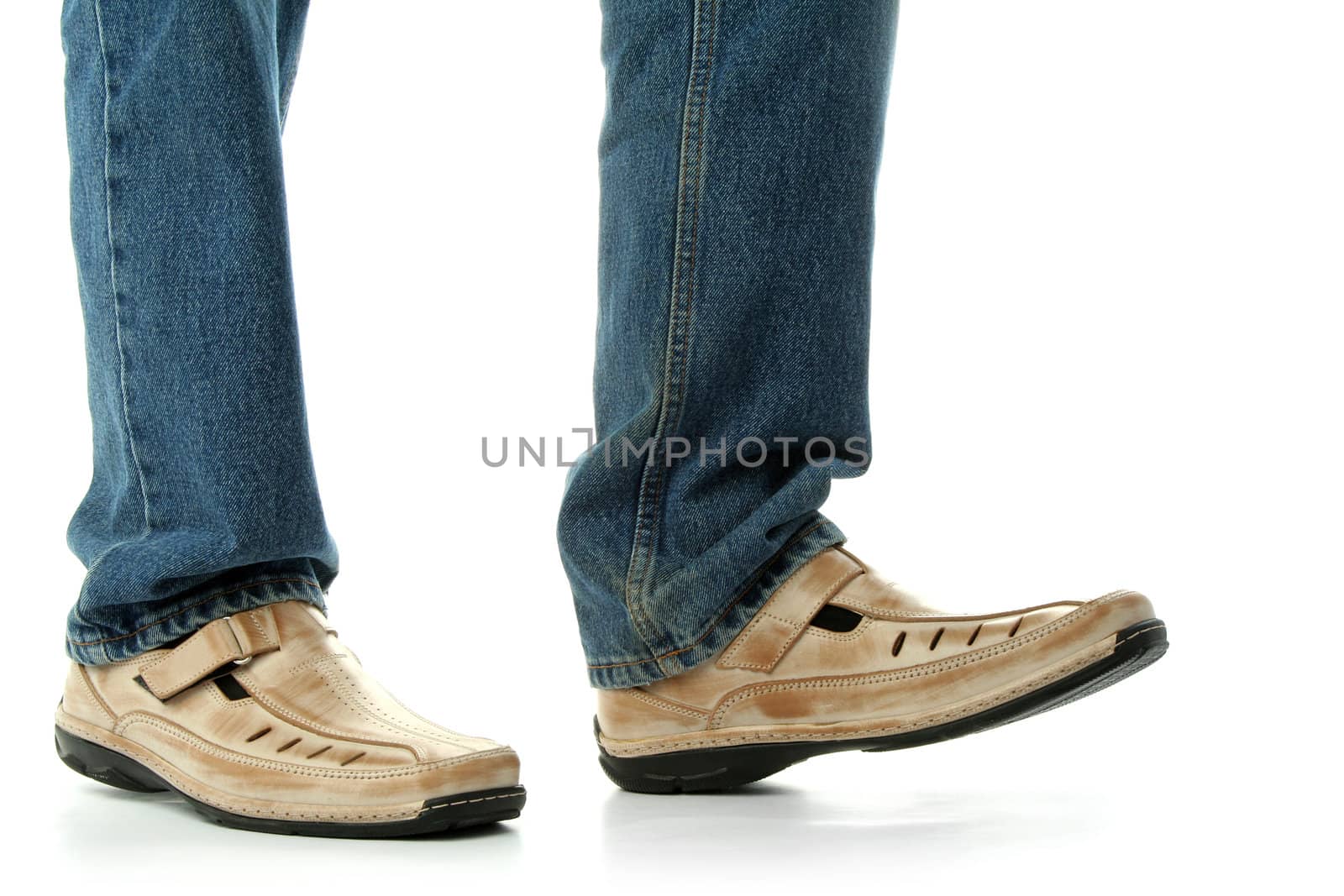 Human foot with brown leather shoes and jeans, isolated on white