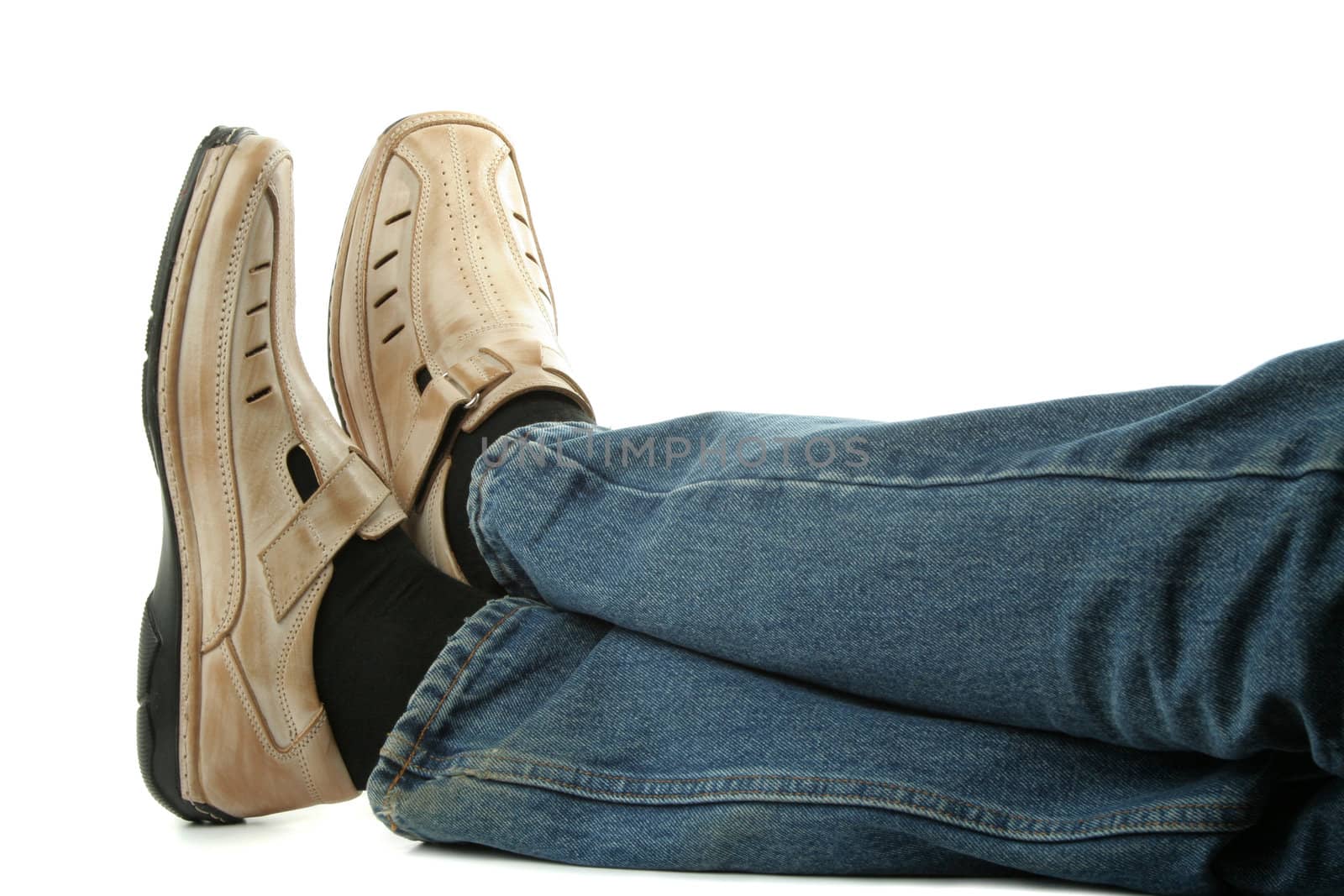 Human foot with brown leather shoes and jeans, isolated on white