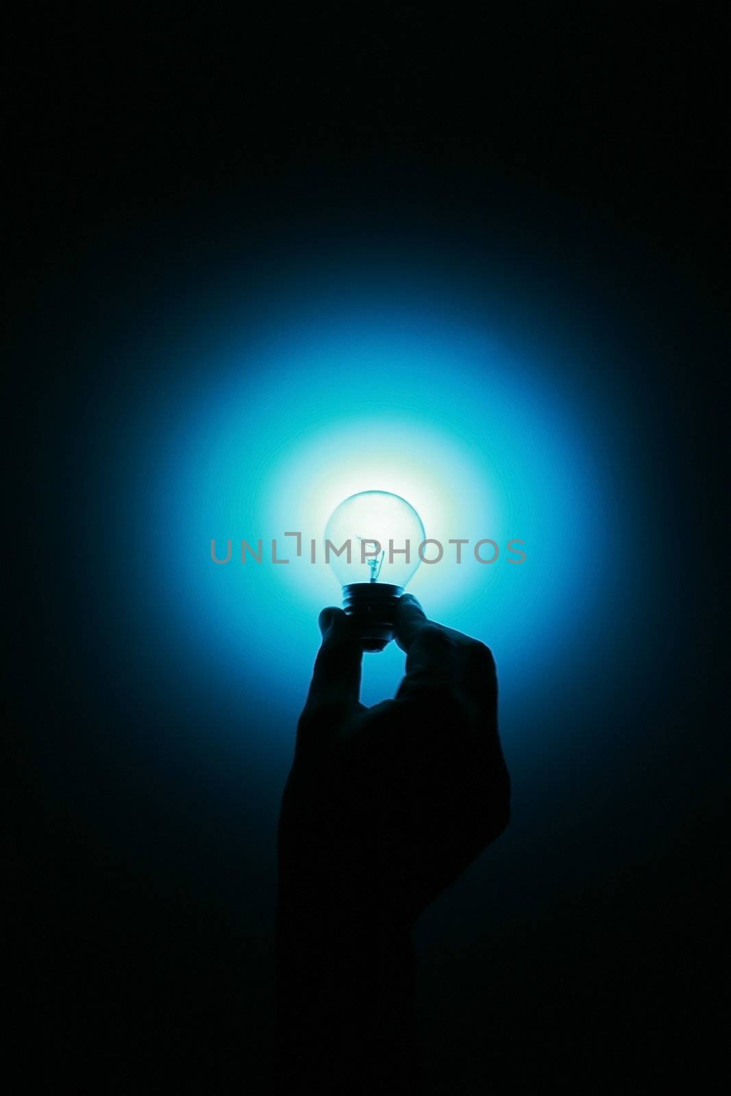 a hand holding a glowing blue light bulb 
