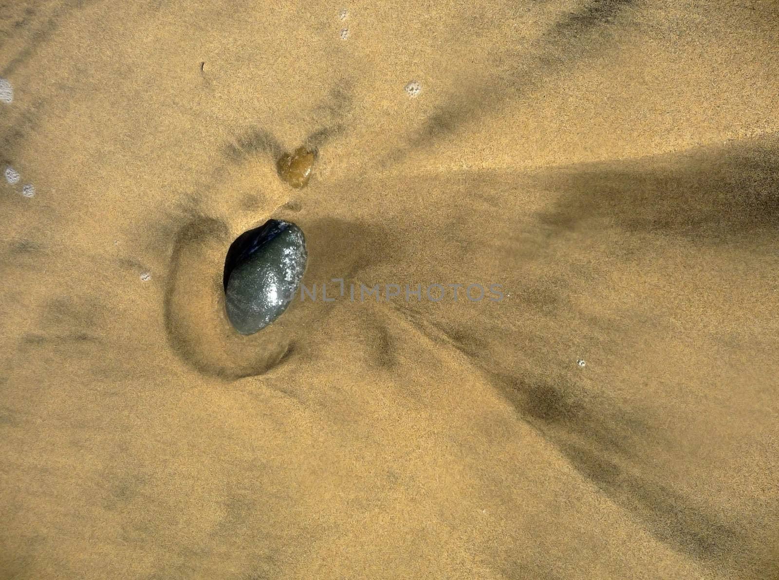 An abstract view of a stone in some beach sand.