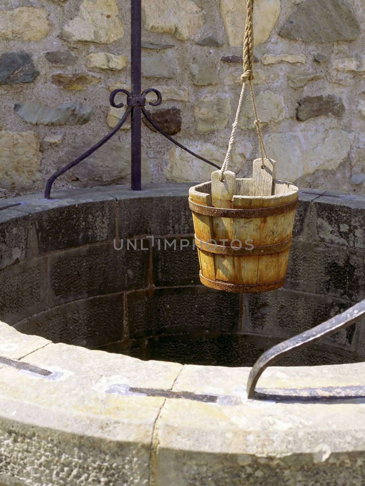 A water well with an old bucket.