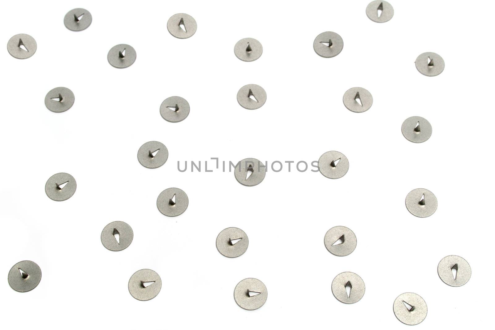 Pile of  thumb tacks nickel plated represent danger to careless workers 