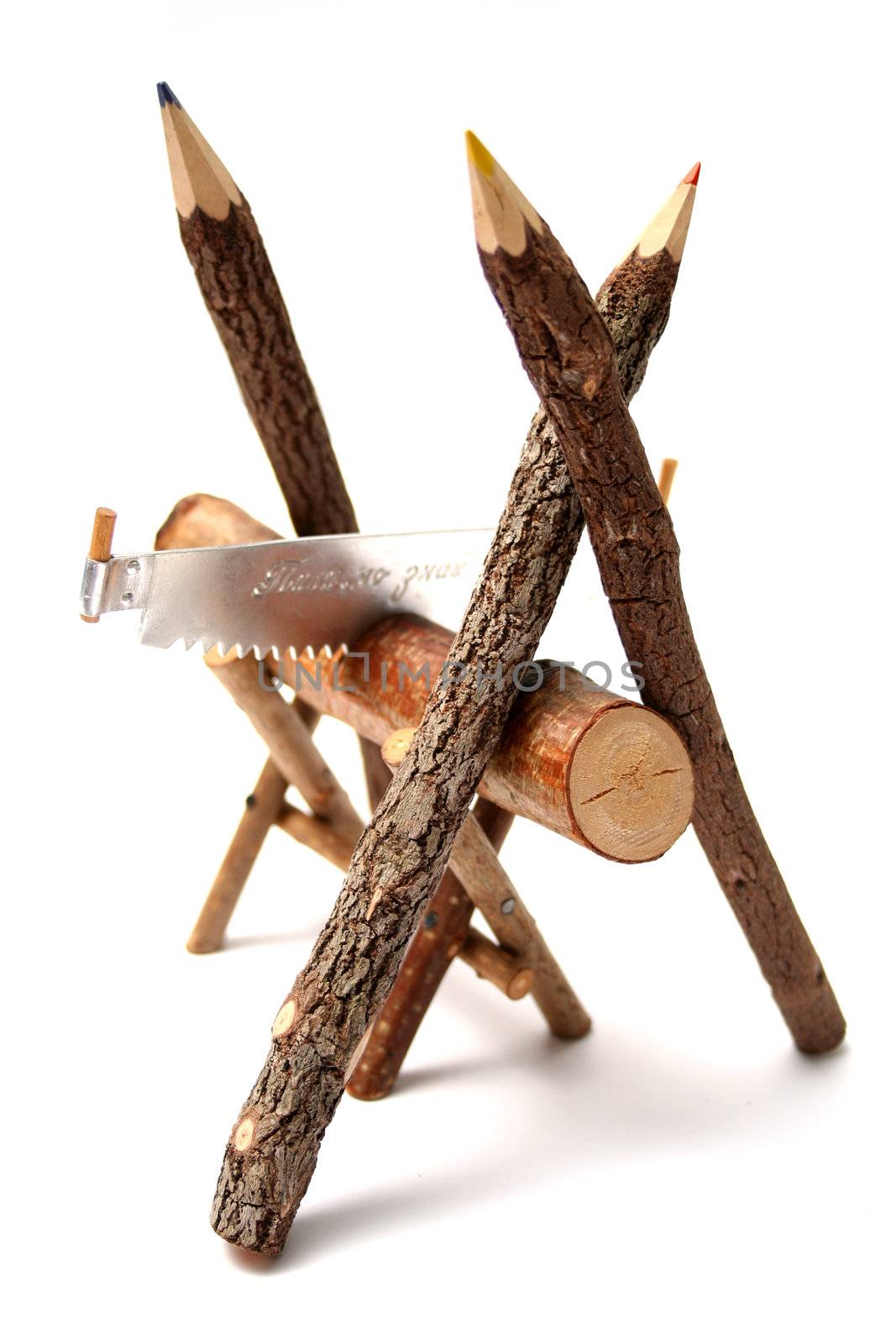 Three color pencils made of branches of a tree glad with a saw and a log vertical