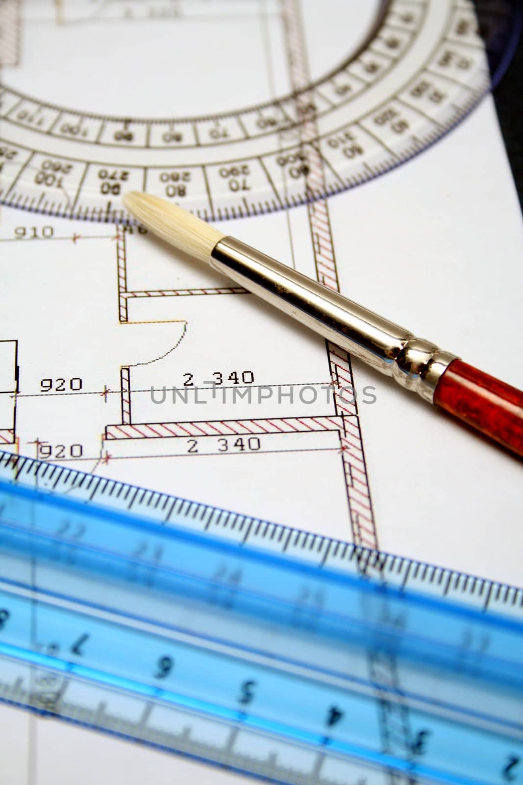 Measuring rulers and art brush on a paper with the plan by parrus