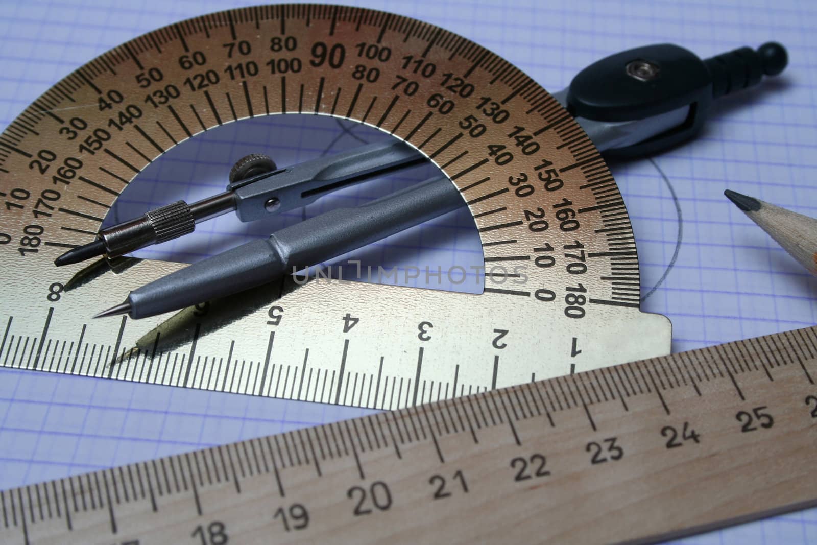 Compasses, pencil and rulers on squared paper