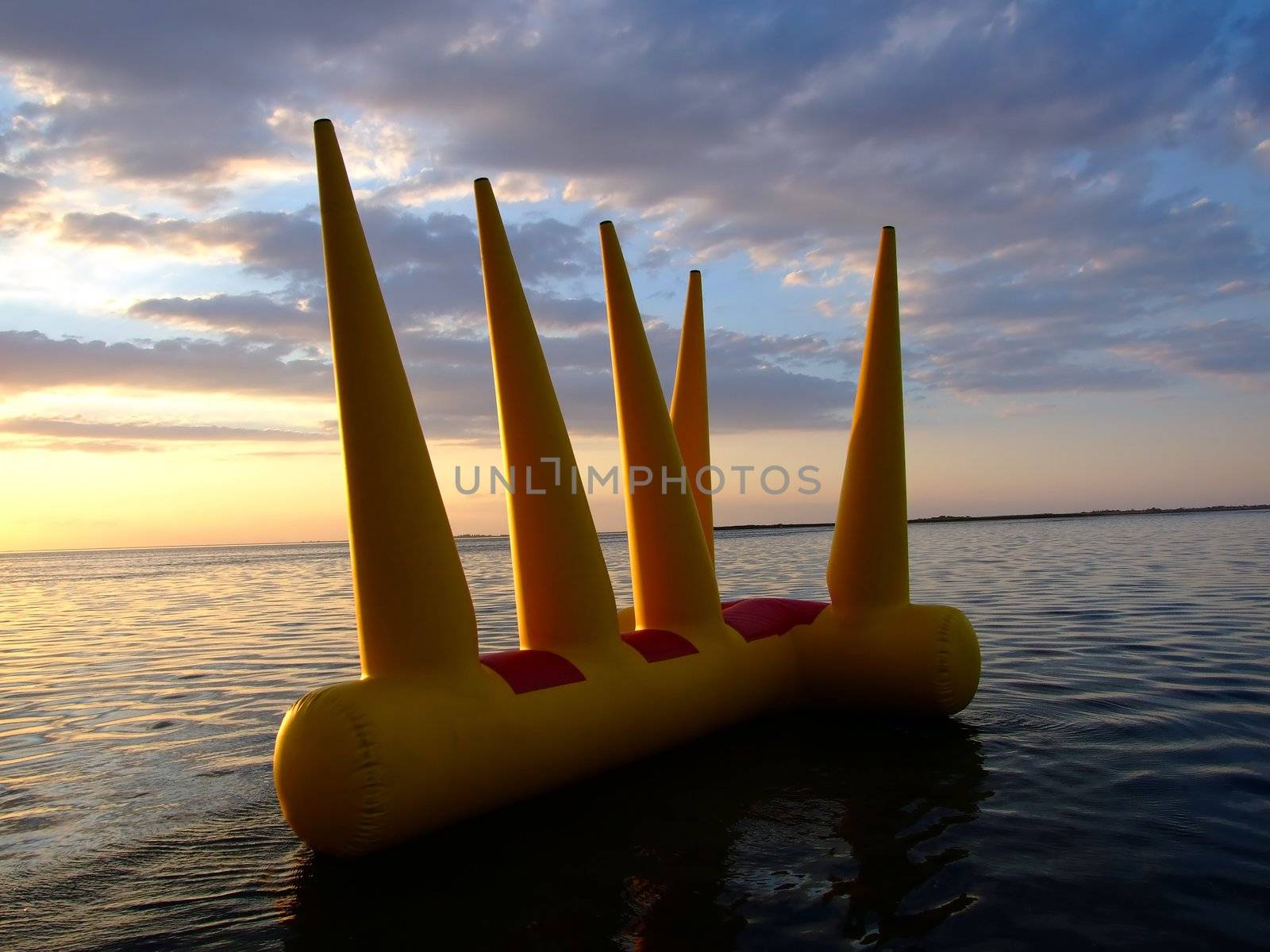 Greater bright inflatable toy on water on a sunset by acidgrey