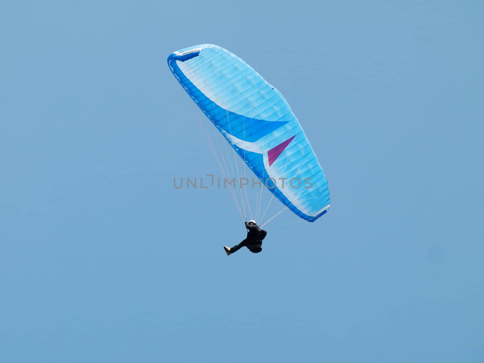 man paragliding over pure blue sky 