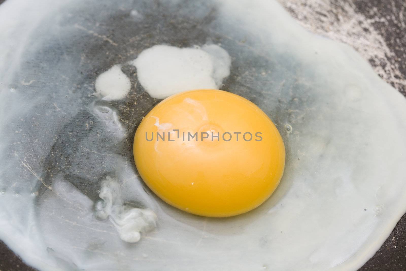 cooking the egg in the frying pan close-up