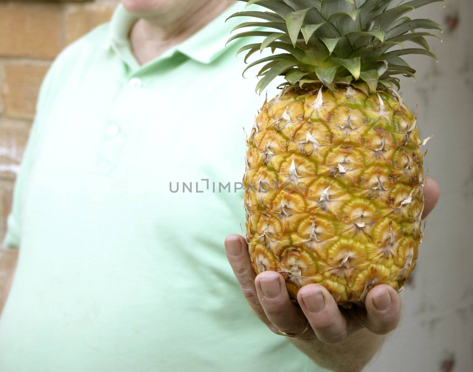 man offering a pineapple 