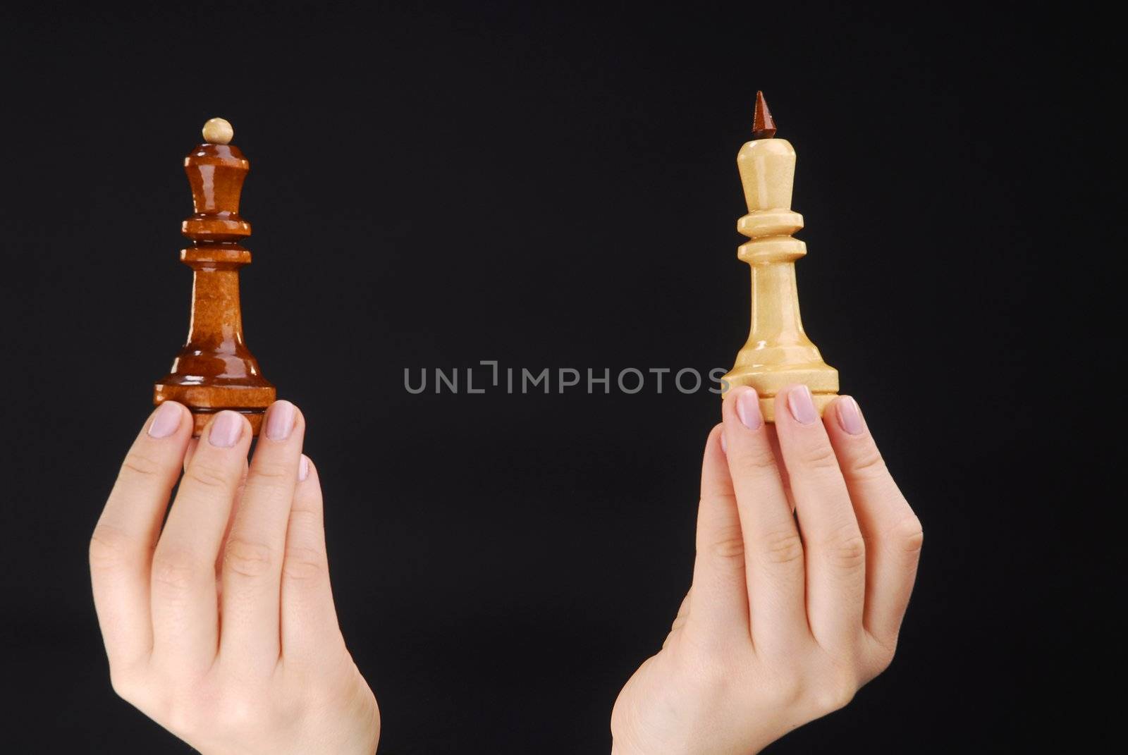 Two hands with black and white chesspieces