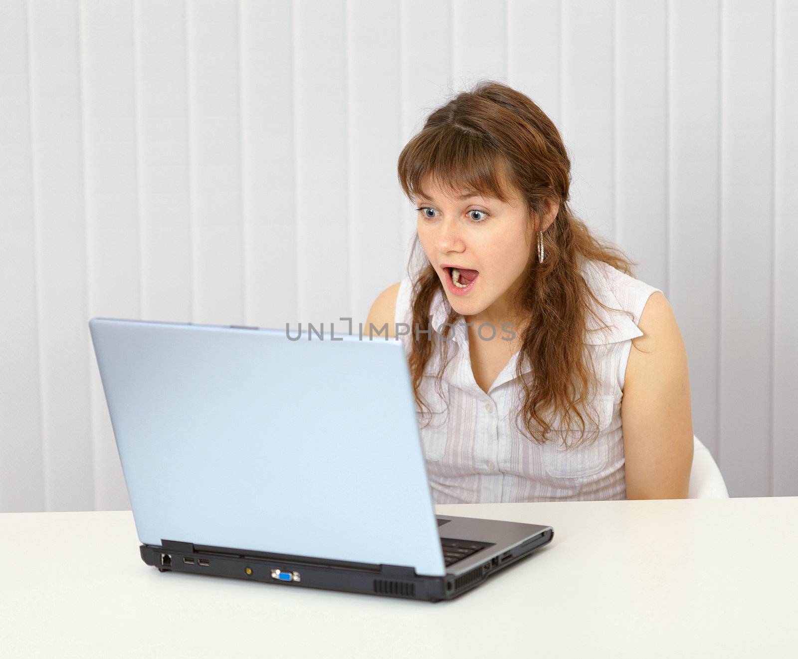Excited, screaming woman looking at laptop screen by pzaxe