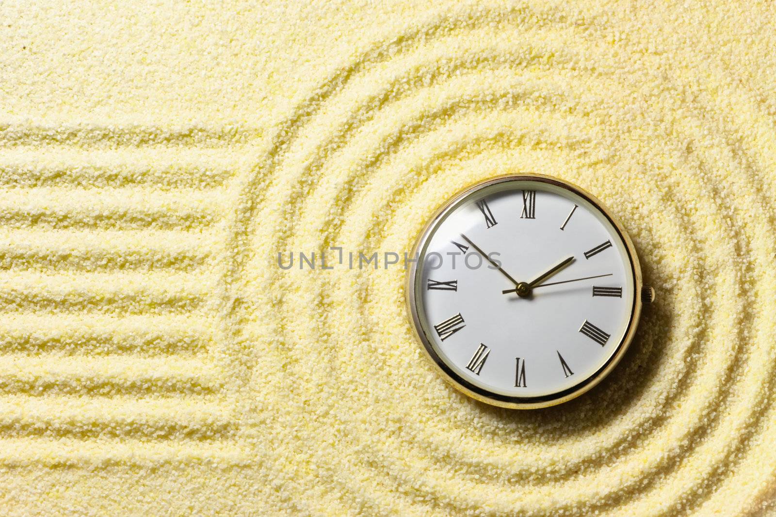 Composition on Zen garden - yellow sand, and watch