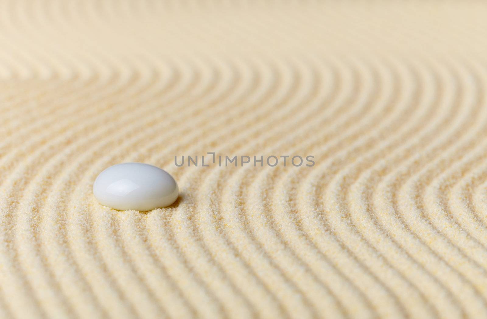 Composition on Zen garden - yellow sand, and glass drop